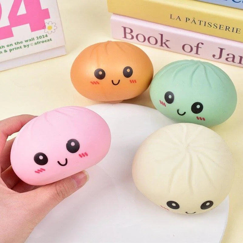 Hand holding pink squishy dumpling stress relief fidget toy
