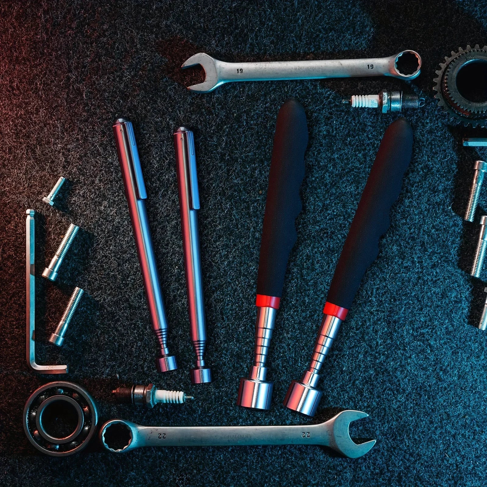 Telescopic magnetic pickup tools on dark workshop background with tools